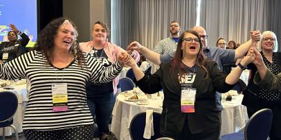 PSRP Conference attendees standing in solidarity